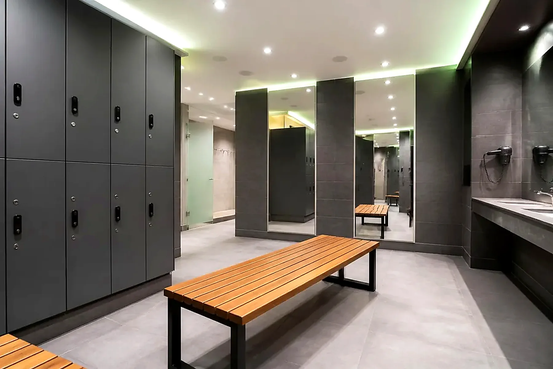 Clean changing room with personal lockers, bench and mirrors