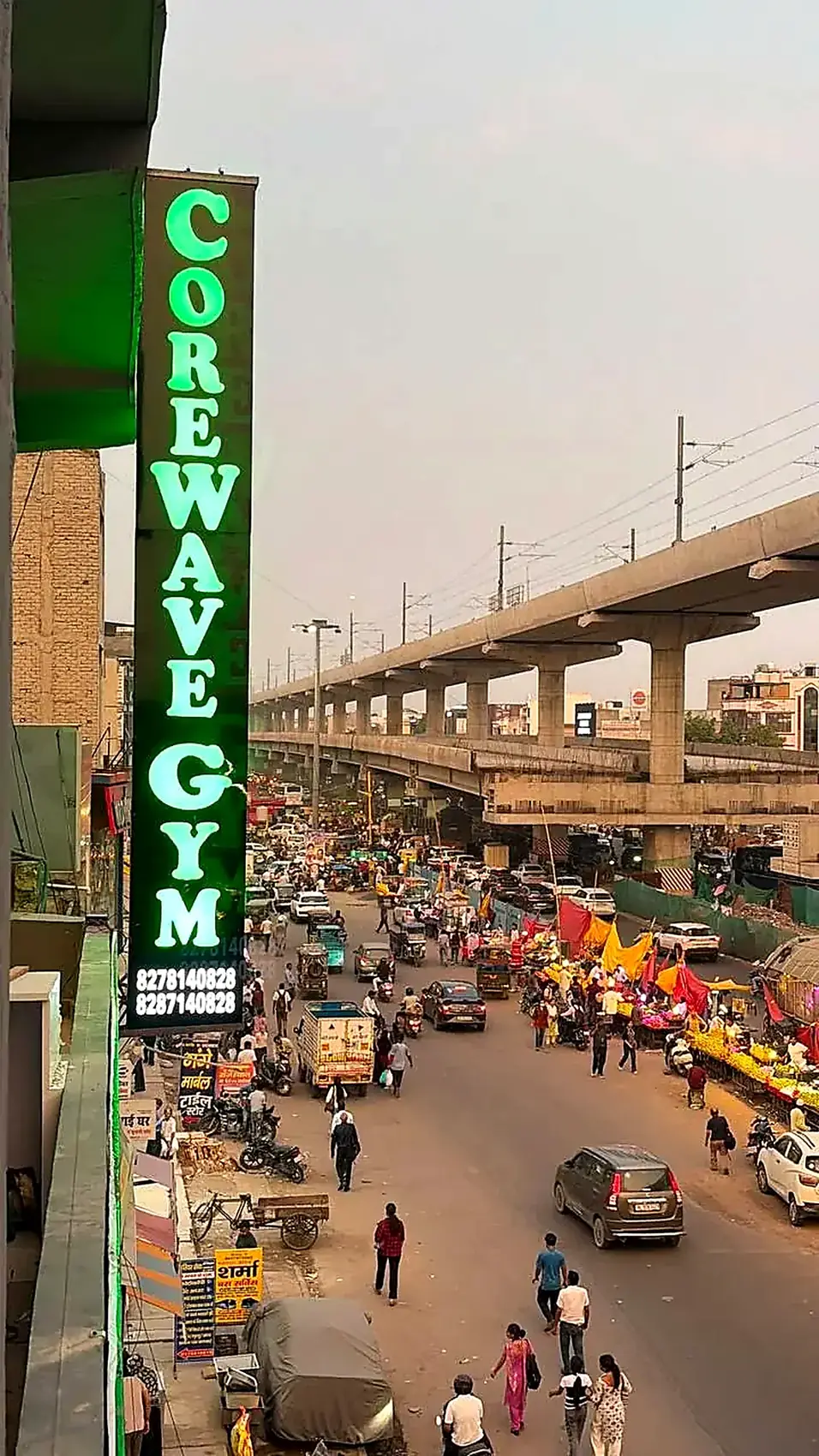 Core Wave Gym green neon signboard on the main road in Bhajanpura, Delhi